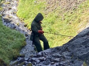 person in raingear holding rope