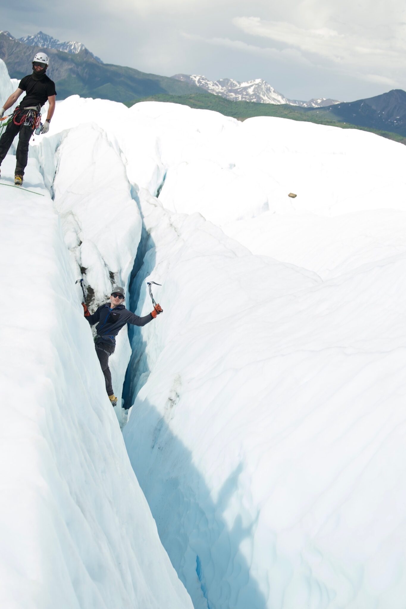 ice climber lifts tool after successful crevasse climb